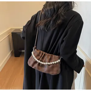 Détail du sac croissant à carreaux marron foncé avec chaîne décorative en perles
