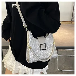 Détail de la texture argentée à écailles et boucle métallique sur le sac à main