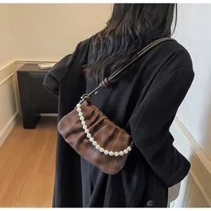 Détail du sac à bandoulière à carreaux avec texture plissée et chaîne en perles
