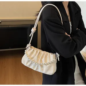 Détail du sac nuage plissé blanc cassé avec chaîne de perles et bandoulière nouée
