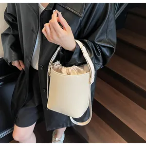 Primer plano del bolso cubo blanco crema con textura de lichi y forro con cordón