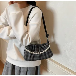 Vue détaillée du sac à carreaux noir et gris avec une élégante chaîne en perles