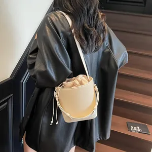 Elegante bolso bombonera crema con cordón y bandolera fina para mujer