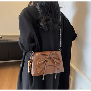 Bolso bandolera vintage marrón con lazo grande y cadena decorativa de cuentas