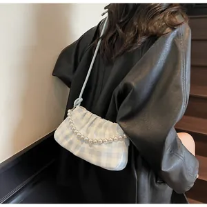Détail du sac à main à carreaux bleu clair avec chaîne en perles et texture plissée nuage