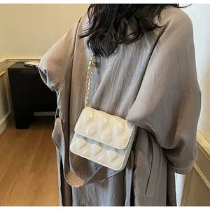Detalle de bolso acolchado blanco con cadena dorada usado como bolso de hombro
