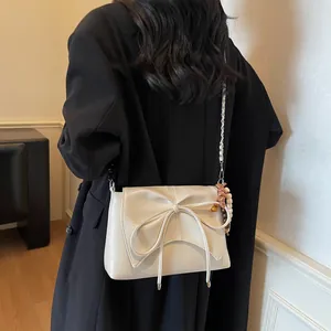 Bolso de hombro crema con lazo grande y accesorio de amuleto con estampado de leopardo