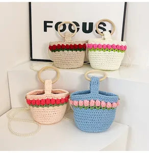 Detalle de flores de tulipán tejidas a mano con asas de madera y cadena de perlas en bolsos