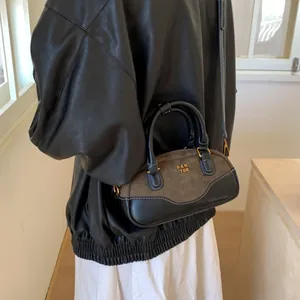 Bolso de mano retro bicolor en ante y cuero con herrajes dorados y doble asa