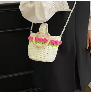 Detalle de bolso cubo de ganchillo con motivos de tulipanes y asa de perlas