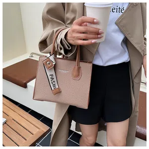 Detail of brown woven tote bag showing fabric texture and FASHION logo strap