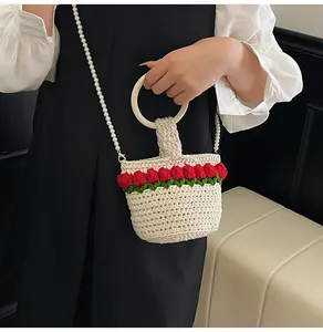 Detalle de bolso tipo cubo de ganchillo con flores tulipán 3D y asa de perlas
