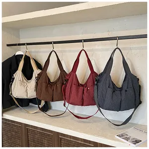 Detalle de cuatro bolsos de cuadros en crema, marrón, rojo y gris en exhibición