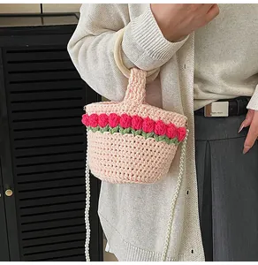 Detalle del bolso tipo cubo de punto rosa con flores de tulipán 3D y asa de perlas