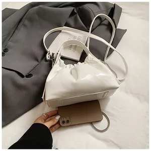 Detalle del bolso de nube blanco brillante con cadena y correa de hombro larga y fina