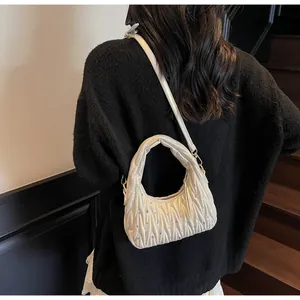 Detalle del bolso hobo plisado crema con diamantes de imitación en el hombro