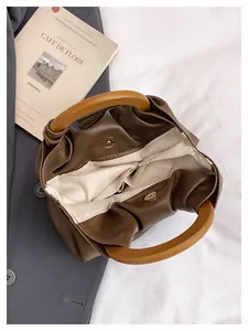 Vista superior del interior del bolso tipo cubo con cierre magnético y asa de madera