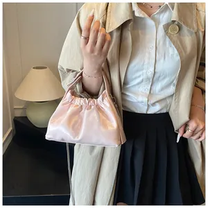 Detalle del bolso fruncido rosa claro con cadena plateada en un entorno de estilo de vida