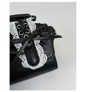 Detalle de bolso de cuero PU negro con adorno de encaje blanco y cordones de corsé
