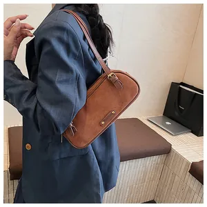 Detalle del bolso hobo de ante caramelo con hebilla ajustable y textura mate fina