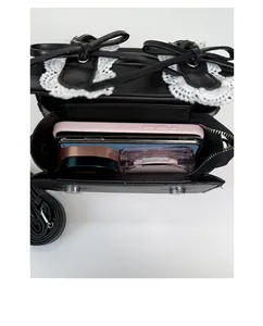Detalle interior del bolso de encaje negro con espacio para móvil y maquillaje