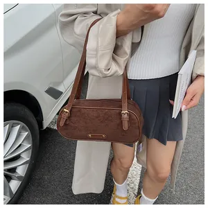 Detalle del bolso de hombro de ante marrón oscuro con asas de cuero ajustables