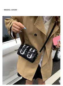 Detalle del bolso bandolera de PU negro con encaje blanco y lazos delicados