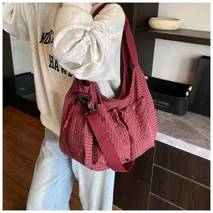 Detalle del bolso tote de cuadros rojos con correa ajustable y bolsillo con solapa