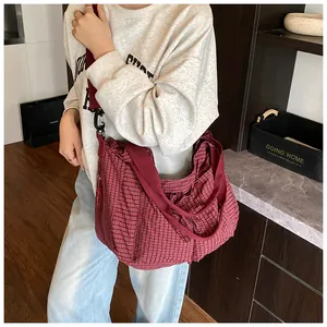 Detalle del bolso tote a cuadros rojo oscuro con correa ancha y hebilla negra