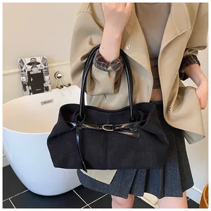 Detalle del bolso tote vintage de pana negra con asas de charol y herrajes dorados