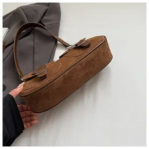 Detalle de bolso retro de ante marrón con elegantes hebillas metálicas dobles