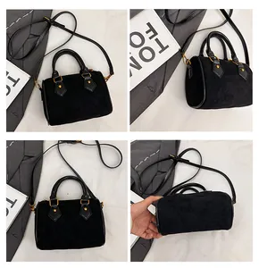 Detalle del bolso acolchado de ante negro con costuras de rombos y remaches dorados