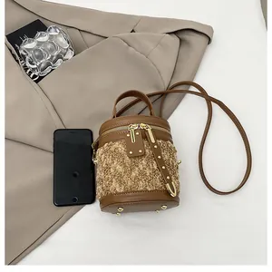 Detalles del bolso tipo cubo en felpa y cuero marrón con herrajes dorados