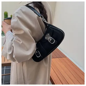 Primer plano del bolso baguette retro de ante negro con hebilla plateada y gabardina