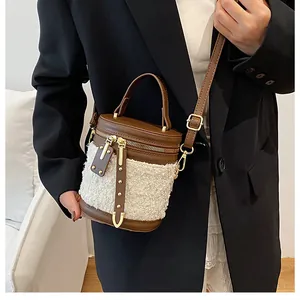 Detalle de patchwork en cuero marrón y lana blanca con herrajes dorados en el bolso