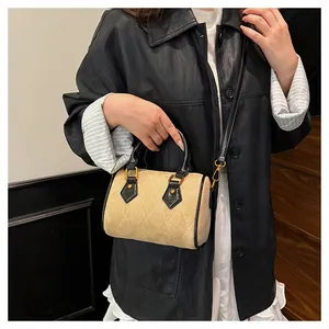 Detalle del bolso bandolera caqui esmerilado con costuras de rombos y adornos de cuero
