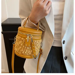 Detalle de bolso cubo amarillo con textura de pelo sintético y remaches metálicos