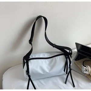 Bolso bandolera cilíndrico de lona blanca con correa negra y tiradores de cremallera largos