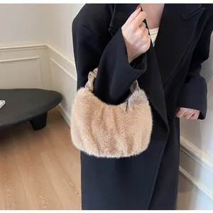 Détail du sac à main en peluche avec poignée plissée en cuir kaki porté par un mannequin