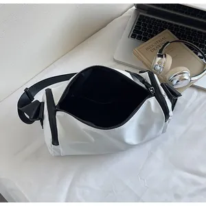 Vista detallada del interior del bolso oxford blanco con forro negro y portátil