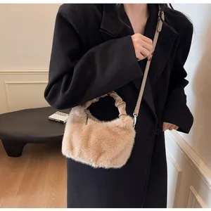Détail du sac à main en peluche beige avec poignée froissée et texture douce