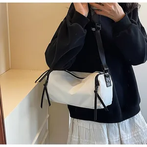 Detalle del bolso cilíndrico blanco en nailon impermeable con cremalleras de borlas