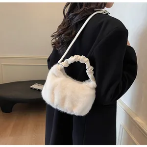 Détail d'un sac à main en fausse fourrure avec poignée en cuir plissée sur manteau noir