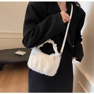 Détail du sac à main en fausse fourrure blanche avec poignées plissées en cuir
