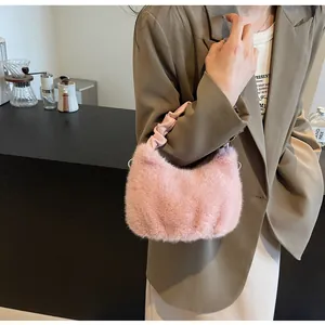 Détail d'un sac à main en peluche rose avec texture douce en fausse fourrure et poignée plissée