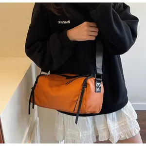 Detalle del bolso cilíndrico de nailon naranja impermeable con cremalleras resistentes