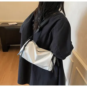 Detalle del bolso bandolera de nailon blanco impermeable con correa negra ajustable