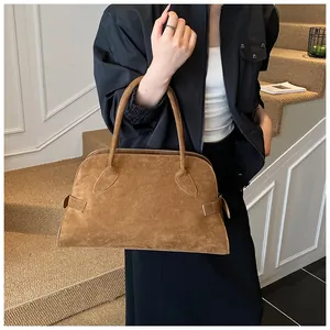 Detalle del bolso tote de ante color caramelo con asas finas y textura mate elegante