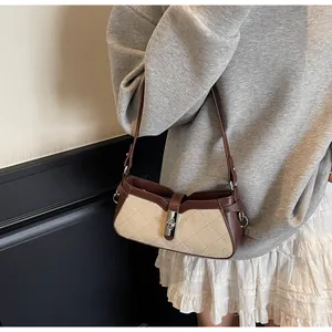 Detalle del bolso acolchado beige vintage con ribetes de cuero marrón y cierre de metal