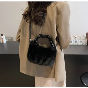 Détail du sac bandoulière en peluche noire avec poignée froncée porté par un mannequin